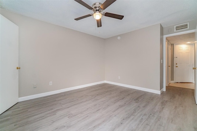 spare room featuring a textured ceiling, ceiling fan, and light wood-type flooring