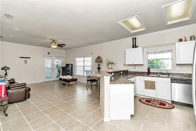 kitchen featuring light tile patterned floors, kitchen peninsula, ceiling fan, dishwasher, and white cabinets