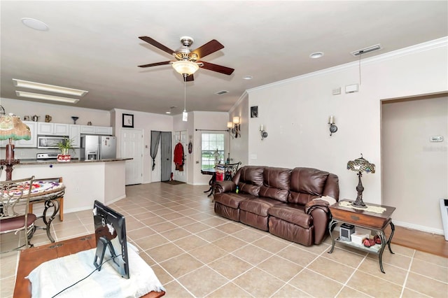 tiled living room with ceiling fan and crown molding