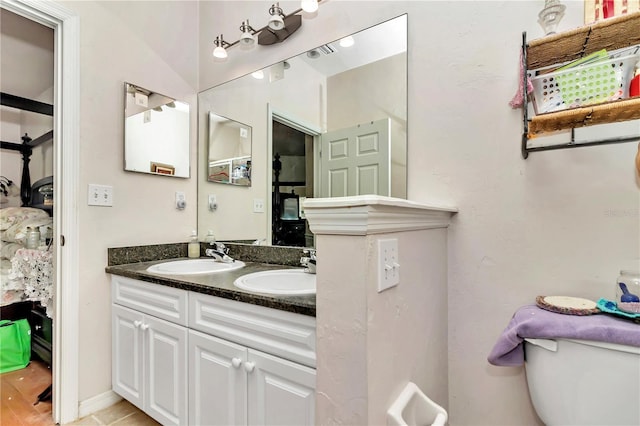 bathroom with toilet, vanity, and tile patterned floors