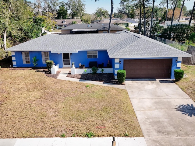 single story home featuring a garage and a front lawn