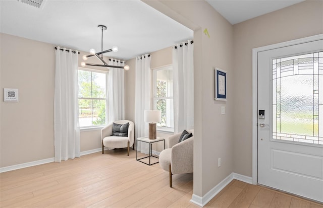 foyer with light hardwood / wood-style floors and a notable chandelier