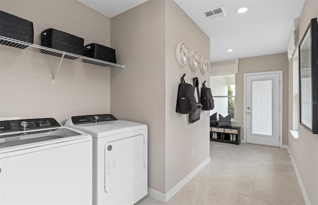 washroom with light tile patterned floors and washing machine and clothes dryer