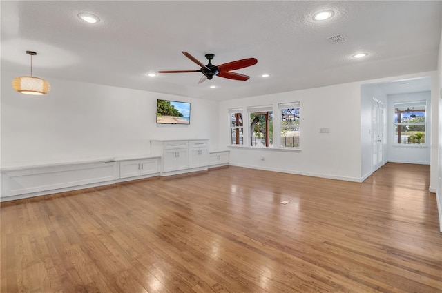 unfurnished living room featuring light hardwood / wood-style floors, a textured ceiling, and ceiling fan