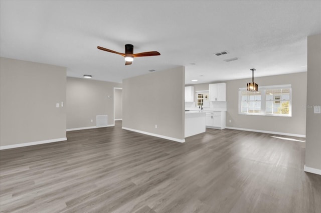 unfurnished living room featuring ceiling fan and hardwood / wood-style flooring