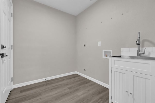 laundry area with hookup for an electric dryer, washer hookup, cabinets, light hardwood / wood-style flooring, and sink