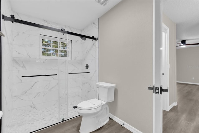 bathroom featuring ceiling fan, hardwood / wood-style floors, an enclosed shower, and toilet