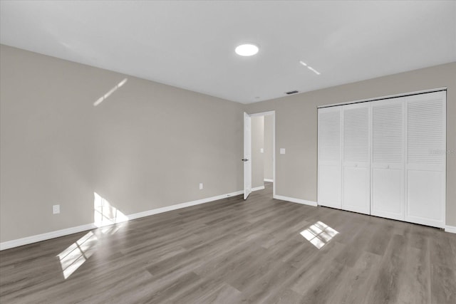 unfurnished bedroom with a closet and hardwood / wood-style flooring