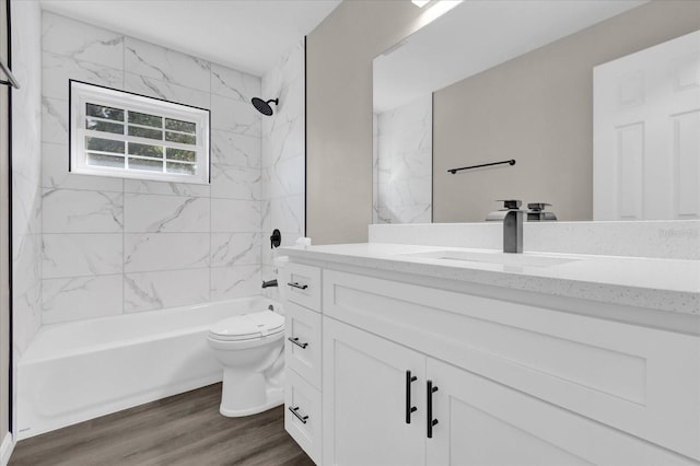 full bathroom featuring hardwood / wood-style floors, toilet, vanity, and tiled shower / bath combo