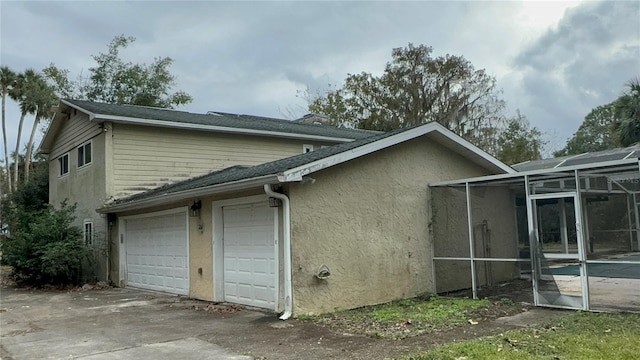 view of side of property featuring a lanai and a garage