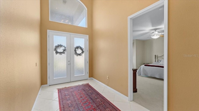 tiled entryway featuring ceiling fan and french doors