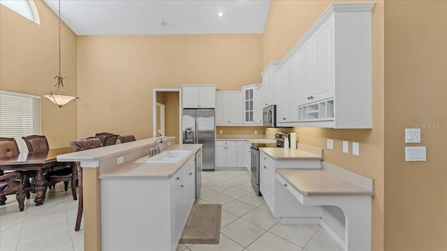 kitchen with white cabinets, sink, appliances with stainless steel finishes, and an island with sink