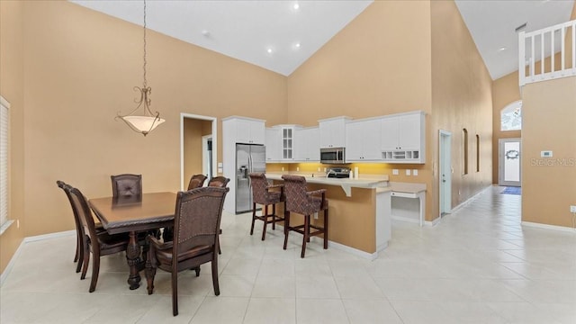 dining room featuring light tile patterned floors and a towering ceiling