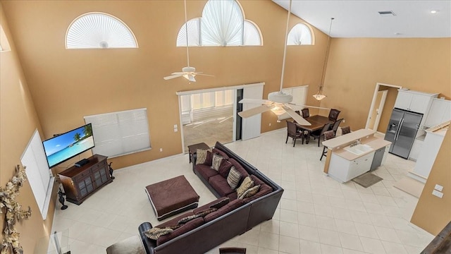 living room featuring ceiling fan and a high ceiling