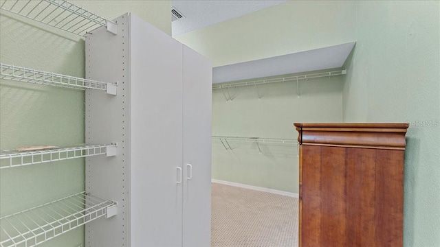 walk in closet with carpet floors