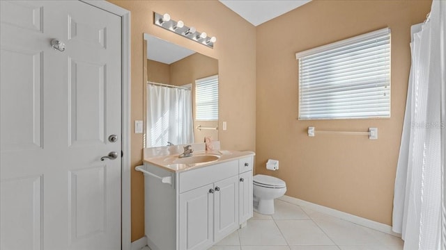 bathroom with toilet, vanity, and tile patterned flooring