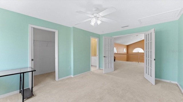 unfurnished bedroom with a spacious closet, light carpet, french doors, a closet, and ceiling fan