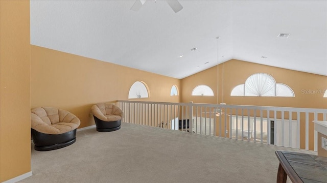 sitting room with ceiling fan, carpet floors, and vaulted ceiling