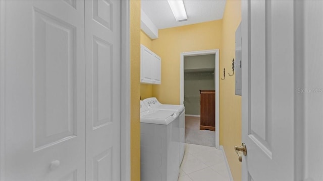 laundry area with light tile patterned floors, independent washer and dryer, and cabinets