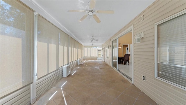 unfurnished sunroom with ceiling fan