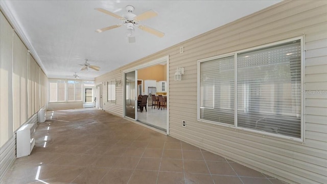 unfurnished sunroom with ceiling fan