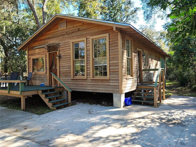 view of front facade featuring a patio area and a wooden deck