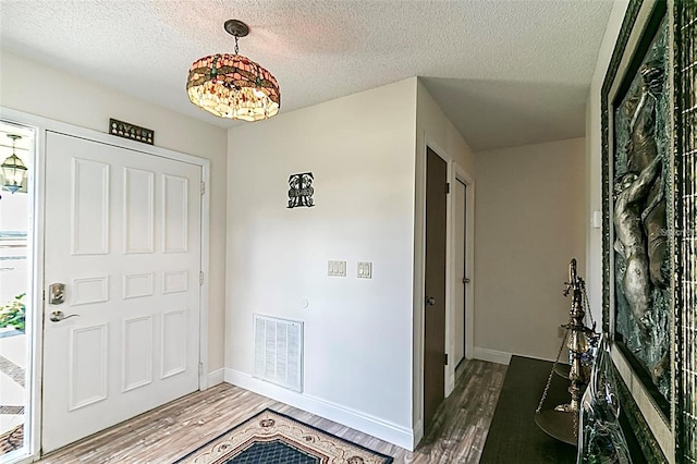 entrance foyer featuring dark hardwood / wood-style floors and a textured ceiling