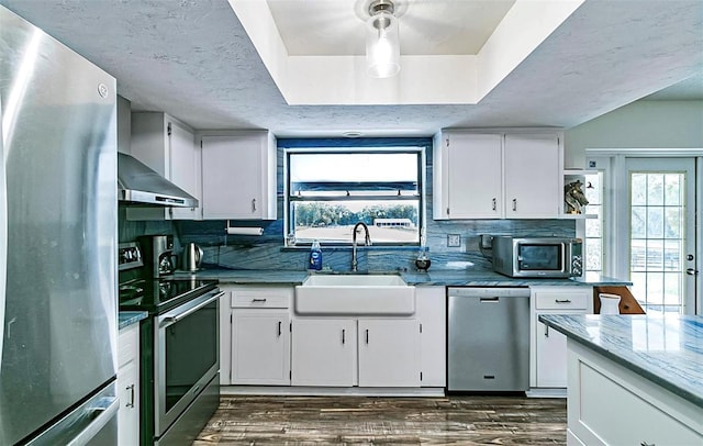 kitchen featuring sink, hanging light fixtures, white cabinets, and stainless steel appliances