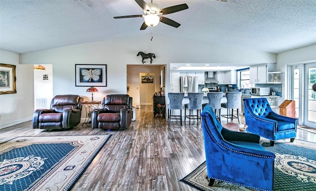 living room with lofted ceiling, wood-type flooring, and a textured ceiling