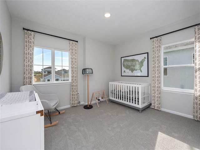 carpeted bedroom featuring a crib