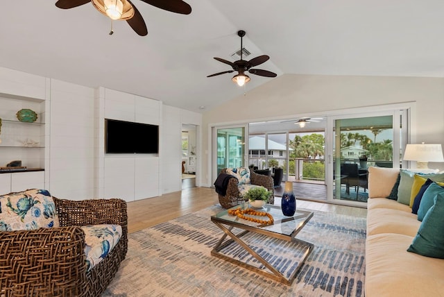 living room with hardwood / wood-style floors, built in features, and lofted ceiling