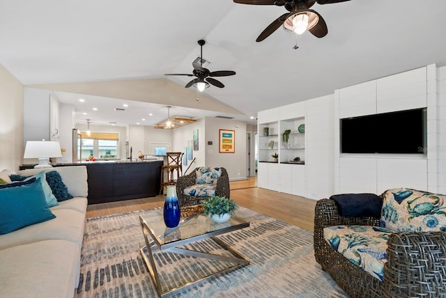 living room featuring light hardwood / wood-style floors, built in shelves, ceiling fan, and vaulted ceiling