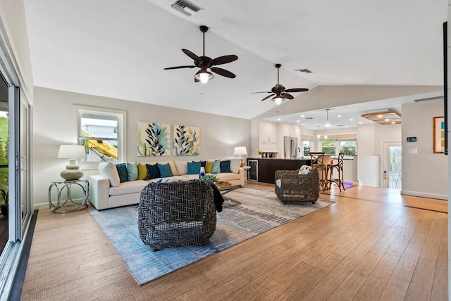 living room featuring a wealth of natural light, light hardwood / wood-style flooring, and lofted ceiling