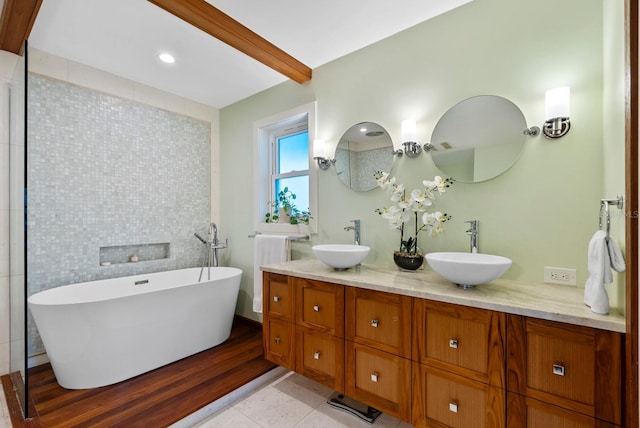 bathroom with tile patterned floors, vanity, tile walls, a washtub, and beam ceiling