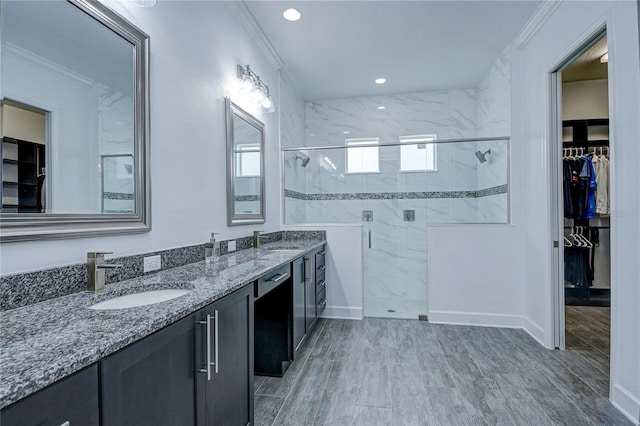 bathroom featuring vanity, crown molding, and walk in shower