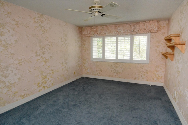 spare room with ceiling fan and dark carpet