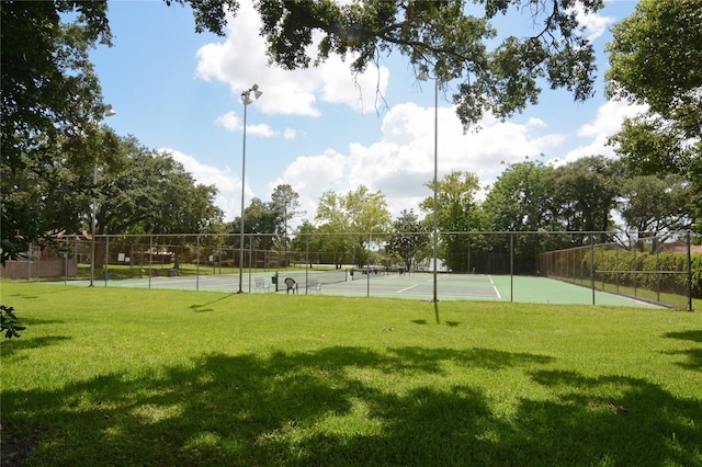 view of sport court featuring a lawn