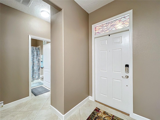 tiled entryway featuring a textured ceiling