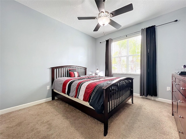 bedroom featuring ceiling fan, light carpet, and a textured ceiling