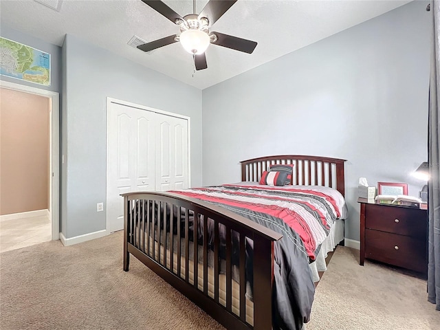 bedroom featuring ceiling fan, light colored carpet, and a closet