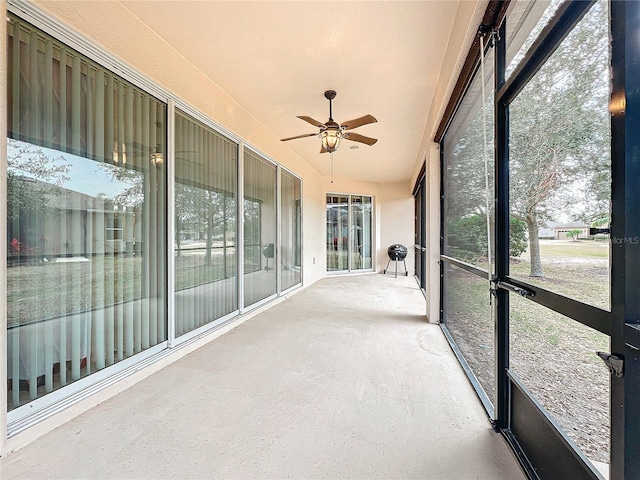 unfurnished sunroom featuring ceiling fan