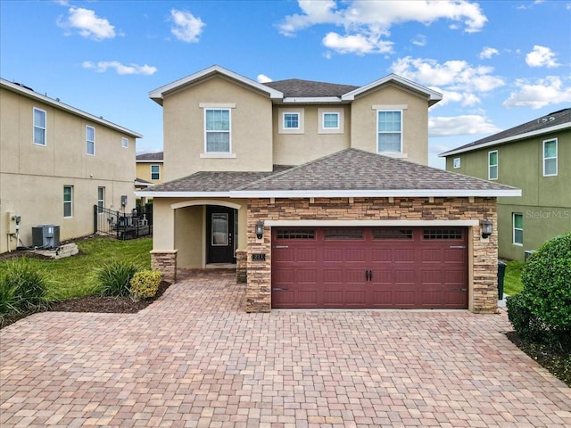 view of front of property featuring a garage and central air condition unit