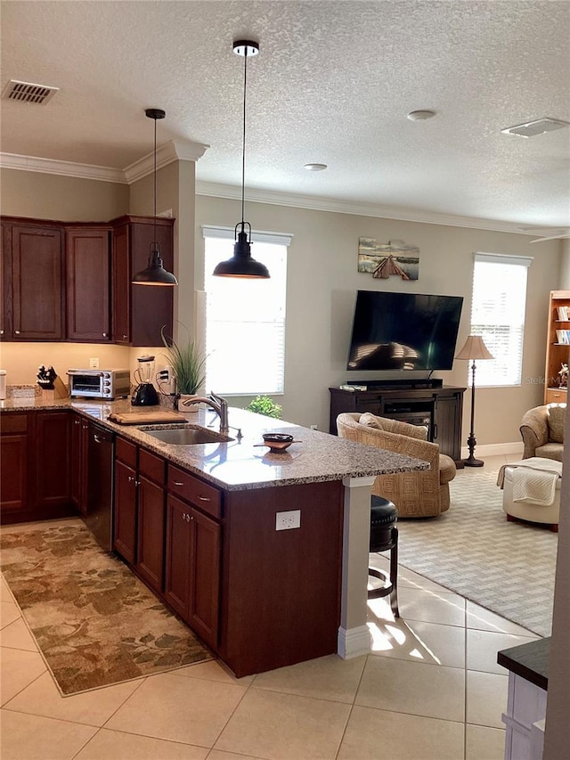 kitchen featuring dishwasher, pendant lighting, sink, light tile patterned floors, and light stone counters