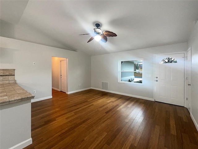 unfurnished living room with ceiling fan, dark wood-type flooring, and vaulted ceiling