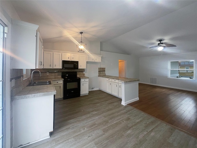 kitchen featuring white cabinetry, sink, hanging light fixtures, and black appliances