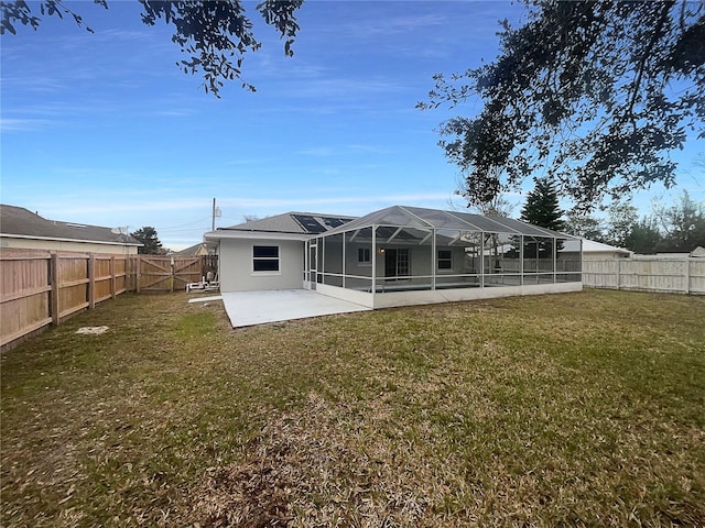 rear view of property with glass enclosure, a patio area, and a yard