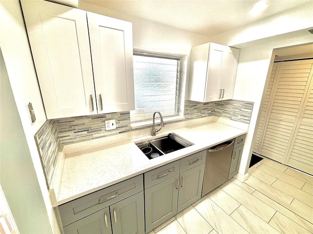 kitchen featuring sink, white cabinetry, dishwasher, and tasteful backsplash