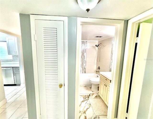 full bathroom featuring toilet, vanity, and tiled shower / bath