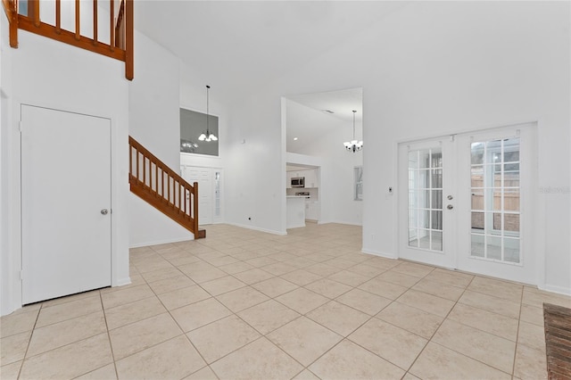 interior space with high vaulted ceiling, light tile patterned floors, french doors, and a notable chandelier