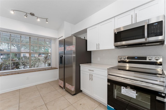 kitchen featuring light tile patterned floors, white cabinetry, and appliances with stainless steel finishes